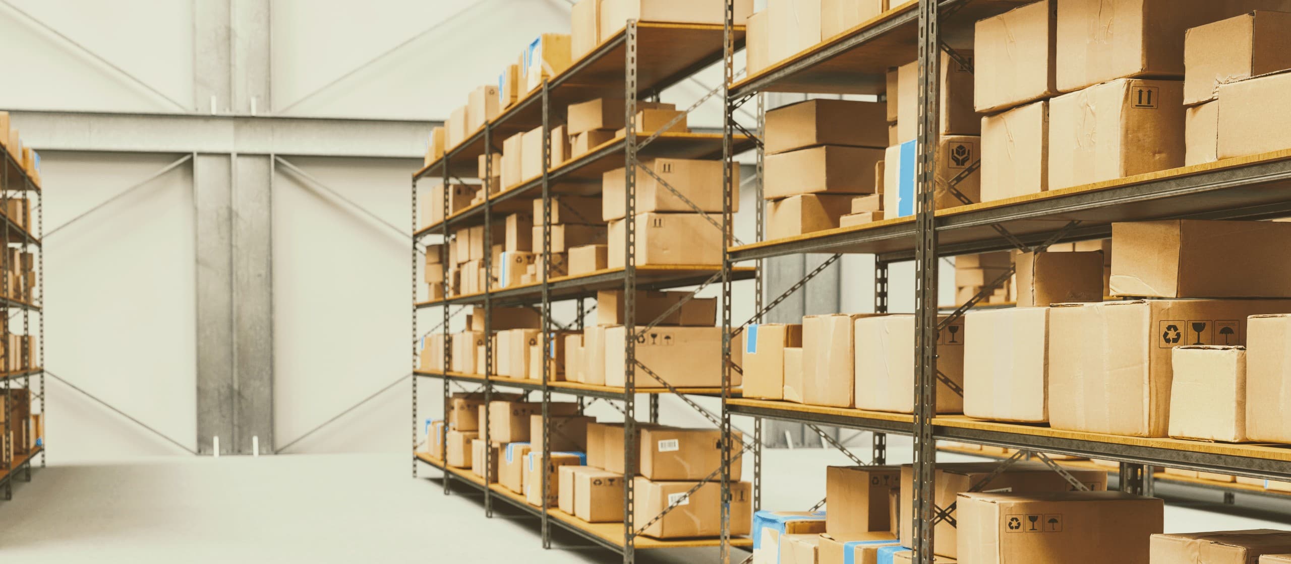 Cardboard boxes stacked on tall metal shelving units inside a large, organized industrial warehouse.